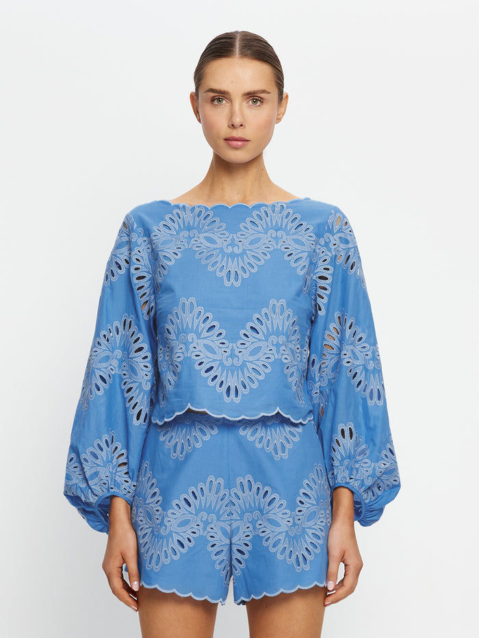Woman wearing a blue lace outfit on a white background