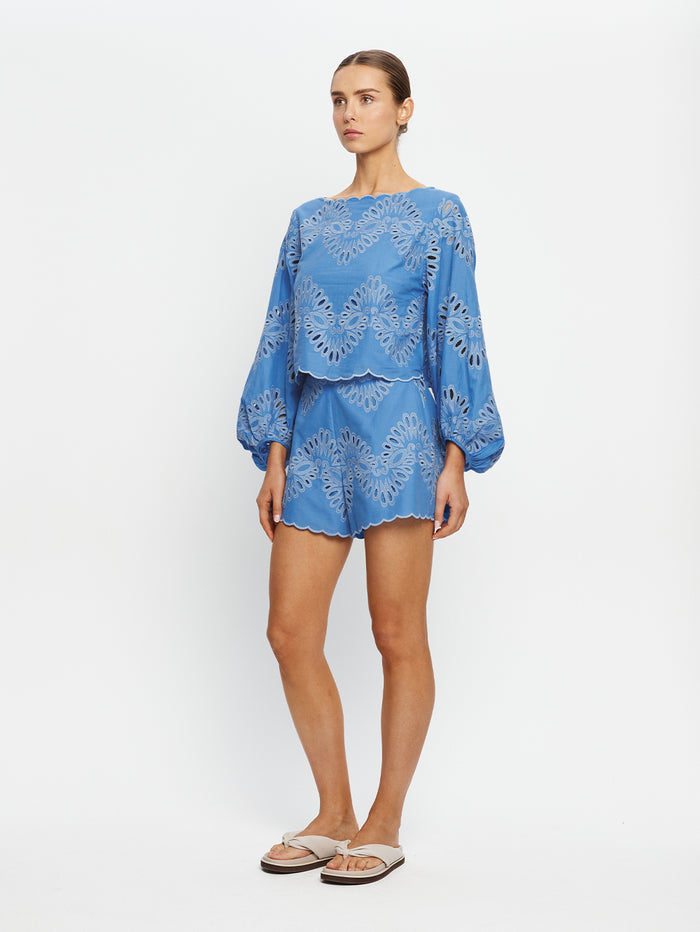 Woman wearing a blue lace set on a white background
