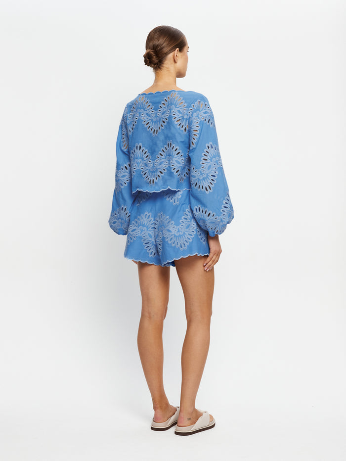 Woman wearing a blue embroidered set on a white background
