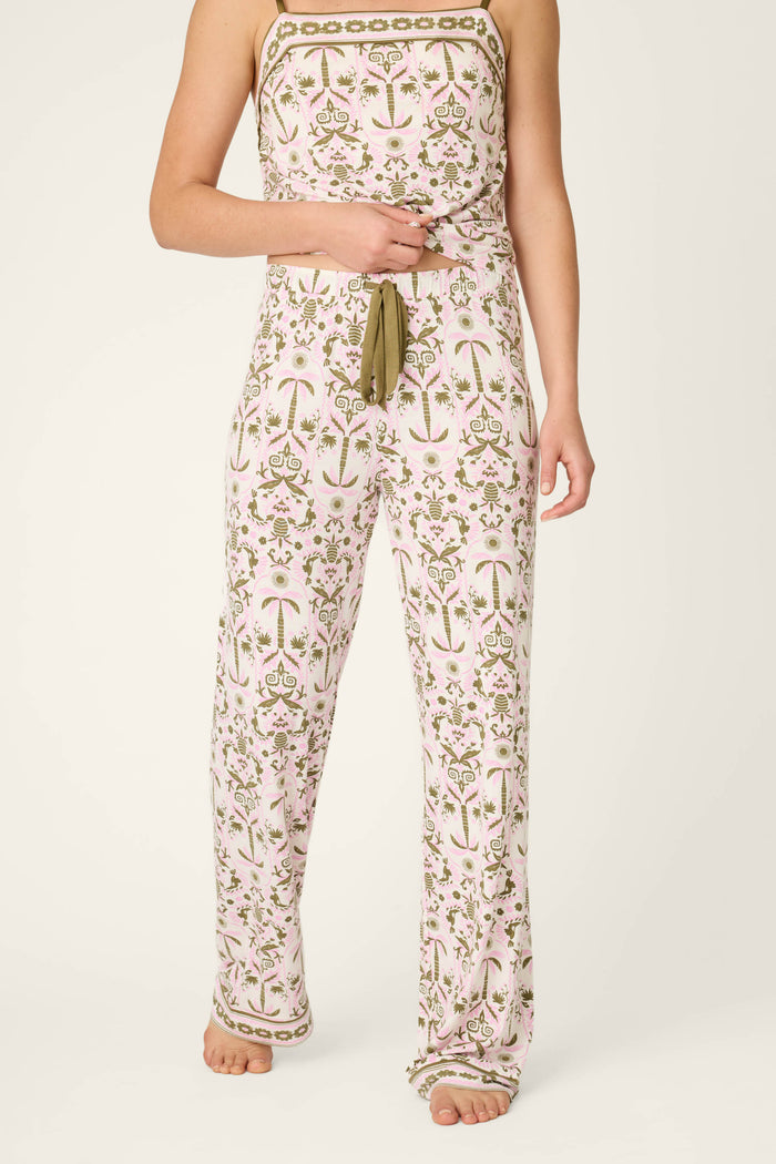 A person stands barefoot against a plain background, wearing P.J. Salvage's Déjà Vu Dreams Tiki Time Open Leg Pants; their head is not visible.
