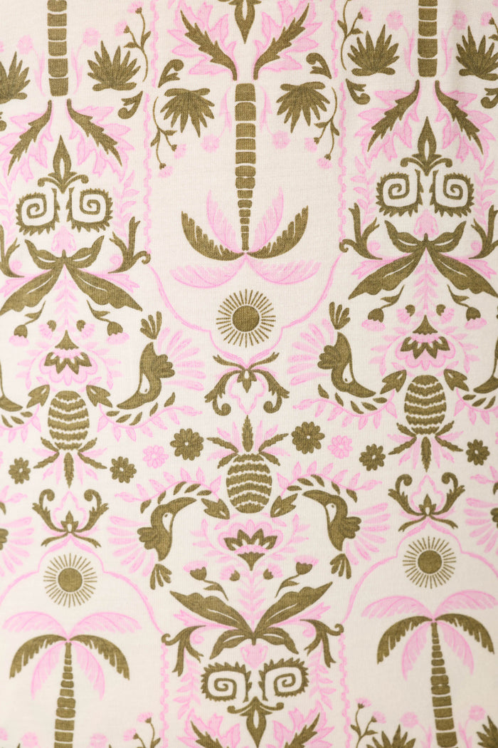 The fabric displays a symmetrical pattern of stylized palm trees, birds, and floral motifs in olive green and soft pink on cream.
