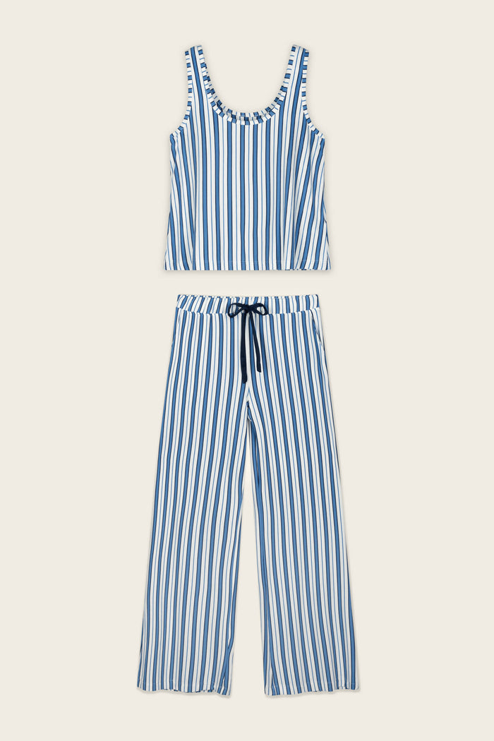 The Soiree Dreams Blue Stripe Tank & Pants PJ Set by P.J. Salvage, featuring a blue and white vertically striped sleeveless tank top and matching wide-leg pants with a drawstring waist, is laid flat on a beige background.